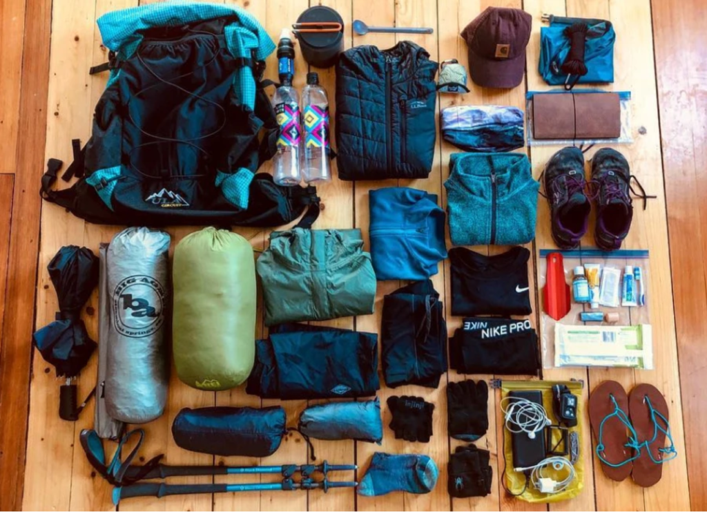 Items needed for a backpacking trip laid out on the floor